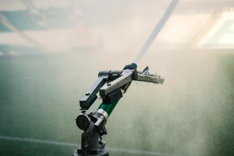 Automatic water irrigator in action. Close-up sprinkler of automatic watering Stock Photos