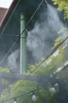 Automatic water spray system to create a cooling effect in hot weather for Stock Photos