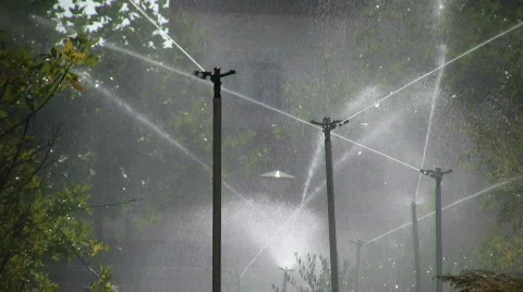 Automatic water sprinkler showering trees Stock Footage 266932