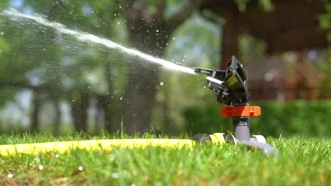 Automatic watering close-up on grass field. Irrigation of green lawn with water. 스톡 동영상 210189049
