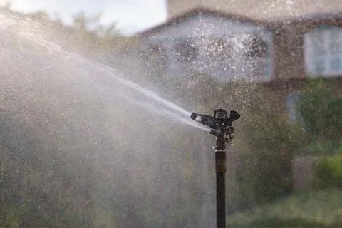 Automatic watering system sprays clean pressurized water droplets on territory Stock Photos