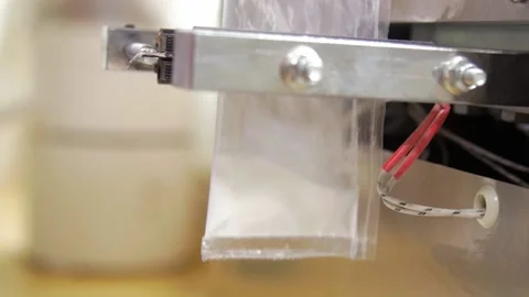 Automatic weighing machine - seal transparent bag with white powder Stockbeeldmateriaal 157233481