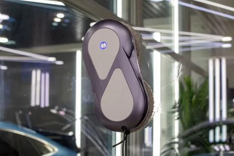 Automatic window cleaning robot washing glass window. Stock Photos