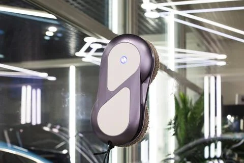 Automatic window cleaning robot washing glass window. Stock Photos