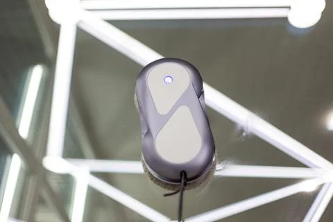 Automatic window cleaning robot washing glass in high-rise building. Stock Photos