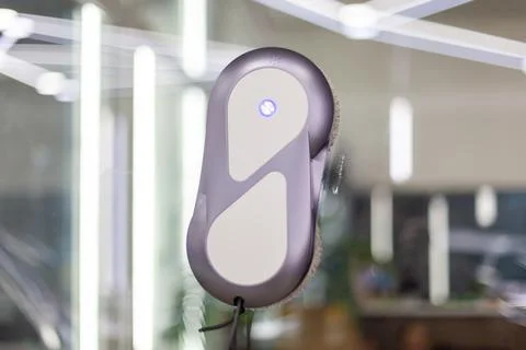 Automatic window cleaning robot washing glass in high-rise building. Fotos de archivo