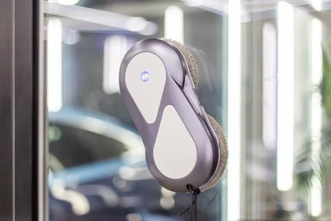 Automatic window cleaning robot washing glass in high-rise building. Stock Photos