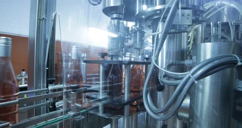 Automatic wine bottle closing machine. Pink wine, beverage, production industry. Stockbeeldmateriaal 94975465