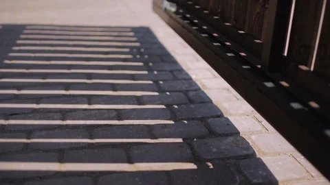 Automatic wooden gates opening with shadow on the driveway Stock Footage 82740956