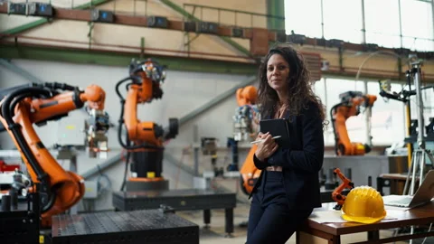 Automation female engineer with tablet for programming robotic arm in factory. 動画素材 197434847