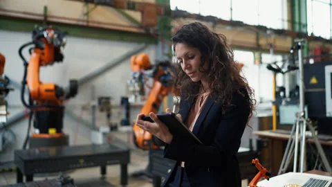 Automation female engineer with tablet for programming robotic arm in factory. Video stock 201143090