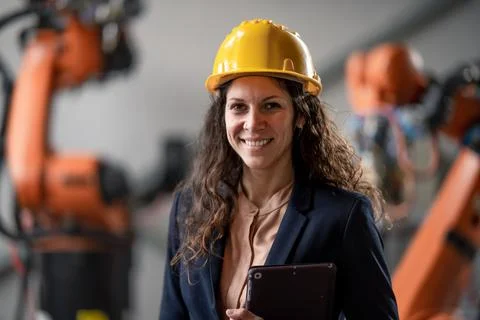 Automation female engineer with tablet for programming robotic arm in factory. Foto stock