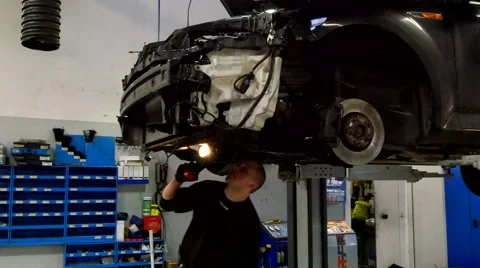 The automechanic is searching with a torch to find errors Stock Footage 60131338