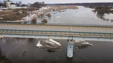 Automobile bridge across a muddy river stream with floating ice floes. Stock Footage 225416181
