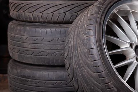 Automobile composition made up stack of tires and wheel with shiny disc in .. Stock Photos