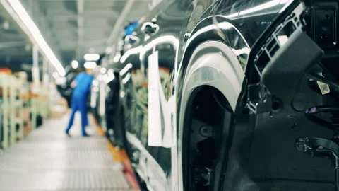 Automobile factory interior. Black colored car body on a car assembly line Stock Footage