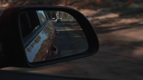 Automobile in motion. View in the rear view side mirror of a auto Видео 311781277
