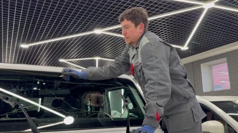 Automobile special workers replacing windscreen or windshield of a car. Stock Footage 317648257