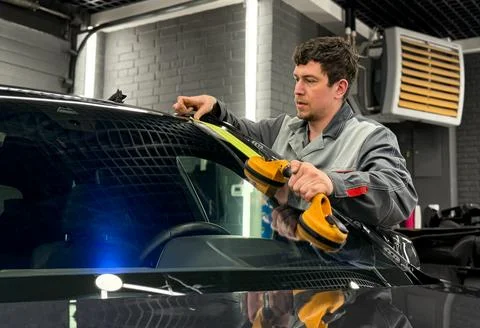 Automobile special workers replacing windscreen or windshield of a car. Stock Photos