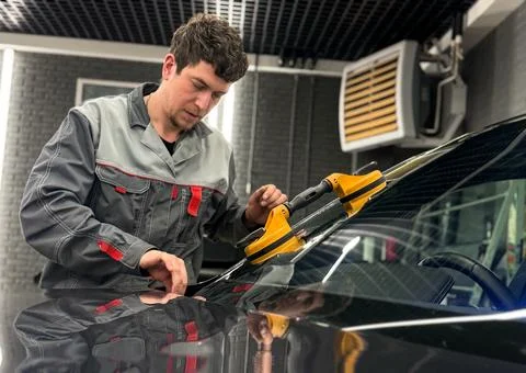 Automobile special workers replacing windscreen or windshield of a car. Stock Photos