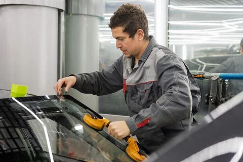 Automobile special workers replacing windscreen or windshield of a car. Stock Photos