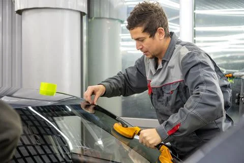Automobile special workers replacing windscreen or windshield of a car. Stock Photos