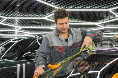 Automobile special workers replacing windscreen or windshield of a car. Stock Photos