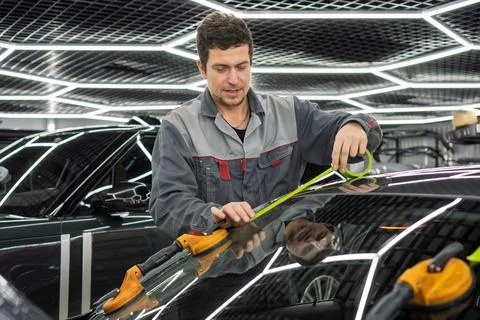 Automobile special workers replacing windscreen or windshield of a car. Stock Photos