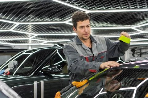 Automobile special workers replacing windscreen or windshield of a car. 写真素材