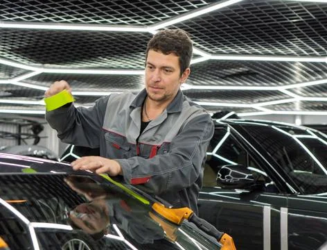 Automobile special workers replacing windscreen or windshield of a car. Stock Photos