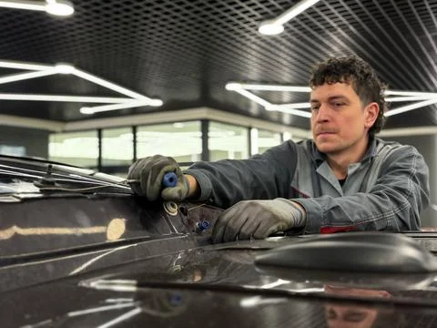 Automobile special workers replacing windscreen or windshield of a car. Stock Photos