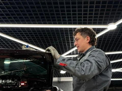 Automobile special workers replacing windscreen or windshield of a car. Stock Photos