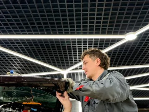 Automobile special workers replacing windscreen or windshield of a car. Stock Photos