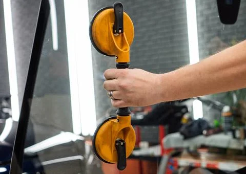 Automobile special workers replacing windscreen or windshield of a car in a.. Stock Photos