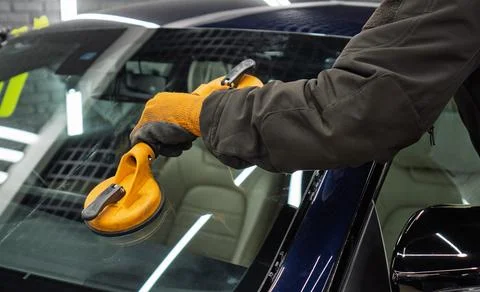 Automobile special workers replacing windscreen or windshield of a car in a.. Stock Photos