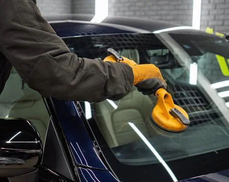 Automobile special workers replacing windscreen or windshield of a car in a.. Stock Photos