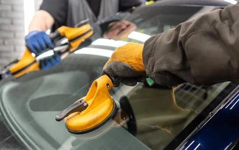 Automobile special workers replacing windscreen or windshield of a car in a.. Stock Photos
