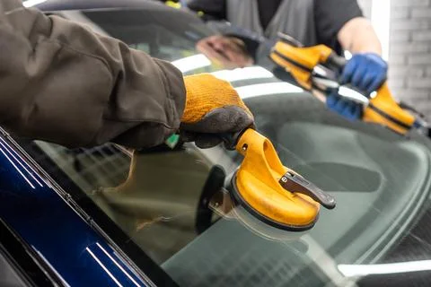 Automobile special workers replacing windscreen or windshield of a car in a.. Stock Photos