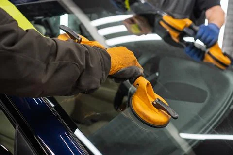 Automobile special workers replacing windscreen or windshield of a car in a.. Stock Photos