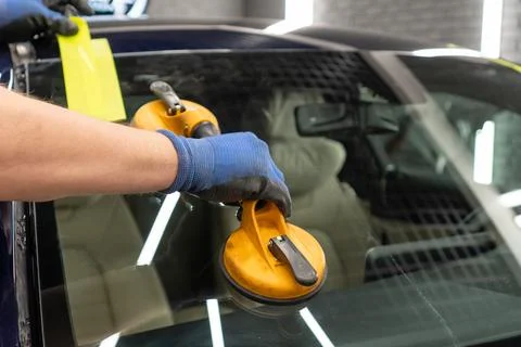 Automobile special workers replacing windscreen or windshield of a car in a.. Stock Photos
