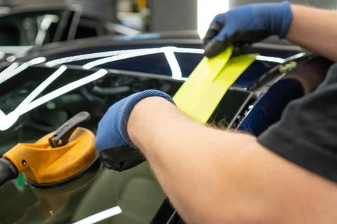 Automobile special workers replacing windscreen or windshield of a car in a.. Stock Photos