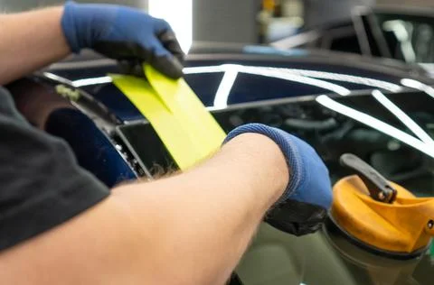 Automobile special workers replacing windscreen or windshield of a car in a.. Stock Photos