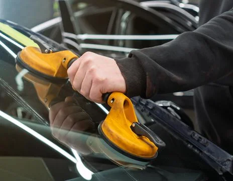 Automobile special workers replacing windscreen or windshield of a car in a.. Stock Photos