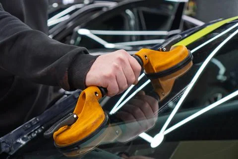 Automobile special workers replacing windscreen or windshield of a car in a.. Stock Photos