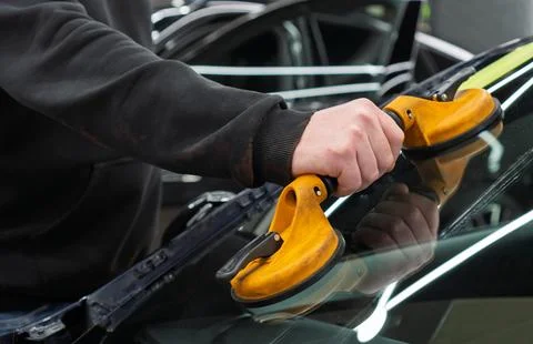 Automobile special workers replacing windscreen or windshield of a car in a.. Stock Photos