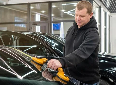 Automobile special workers replacing windscreen or windshield of a car in a.. Stock Photos