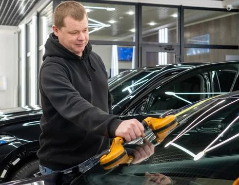 Automobile special workers replacing windscreen or windshield of a car in a.. Stock Photos