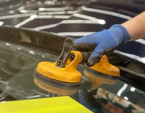 Automobile special workers replacing windscreen or windshield of a car in a.. Stock Photos