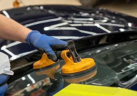 Automobile special workers replacing windscreen or windshield of a car in a.. Stock Photos