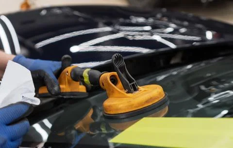 Automobile special workers replacing windscreen or windshield of a car in a.. Stock Photos
